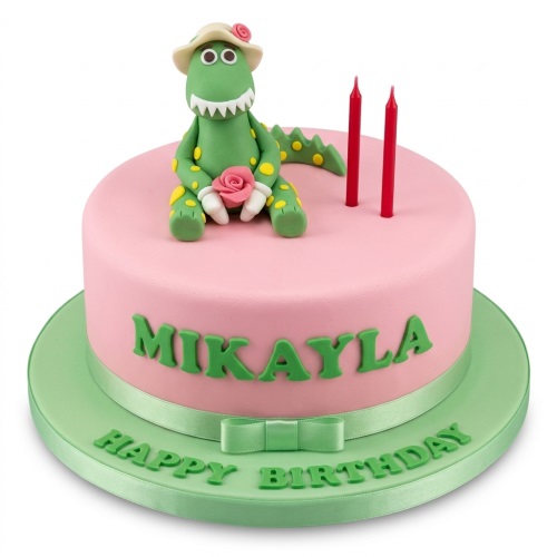 Pink birthday cake with Dorothy the Dinosaur figurine, green lettering, and red candles.