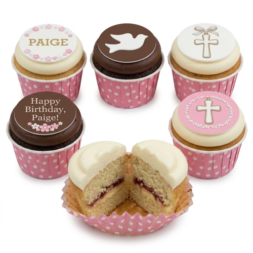 Christening cupcakes with white and pink cross and dove toppers, some with floral details.
