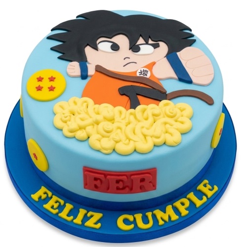 Round light blue cake with a large edible Goku character, yellow power aura, and Dragon Balls on the side.