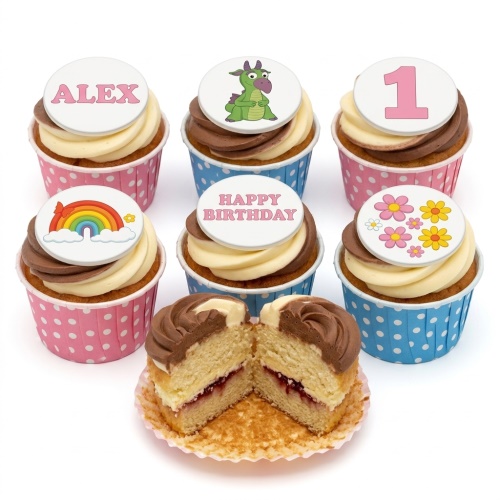A selection of kids birthday cupcakes with two-tone frosting, pink and blue polka dot cases, and toppers featuring a dragon, rainbow, flowers, and a number one.