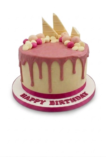 Round pink drip birthday cake with chocolate decorations and 'Happy Birthday' message