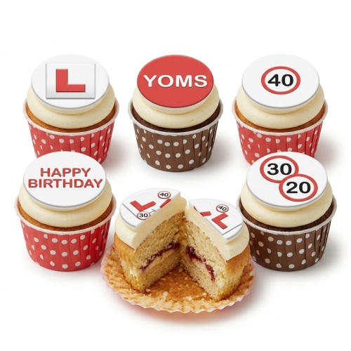 Six cupcakes with cream frosting, red and brown polka dot cases, and edible toppers featuring an L-plate, speed limit signs (20, 30, 40), 'YOMS', and 'Happy Birthday'. One cupcake is cut open to show sponge and jam filling.