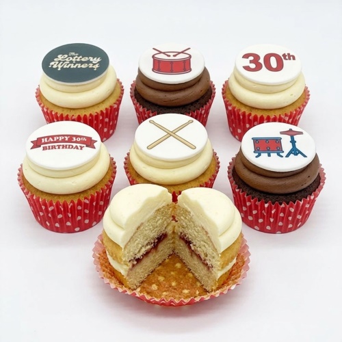 Vanilla and chocolate cupcakes with white and brown frosting, topped with red drumming theme edible decorations and custom birthday messages.