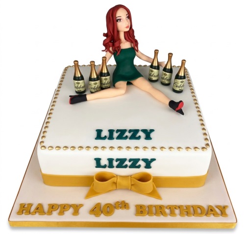 White rectangular cake with a glamorous female figurine, miniature champagne bottles, gold trim, and a custom message.