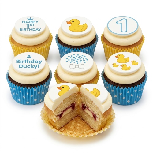 Set of 1st birthday cupcakes for boys with rubber ducky and number one toppers in yellow and blue cases.