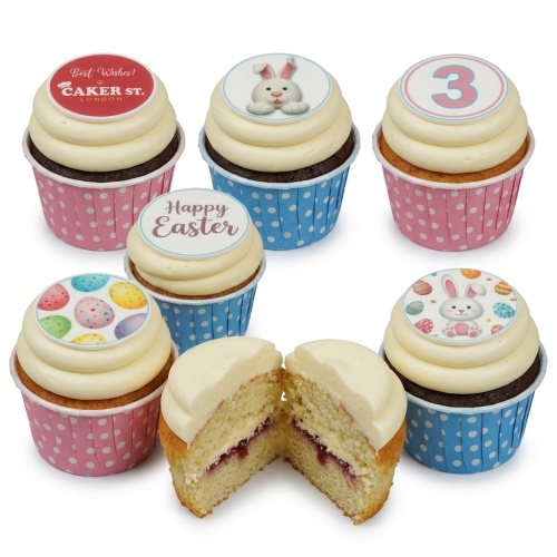 Easter cupcakes with white frosting, edible toppers of Easter bunnies, colourful eggs, and 'Happy Easter' message.