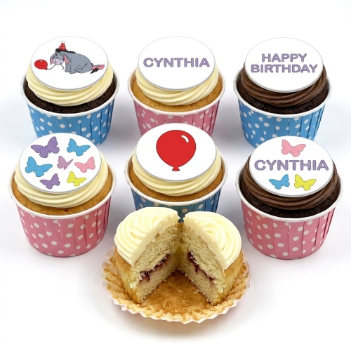A selection of Eeyore, butterfly, and balloon themed cupcakes with personalised message toppers.