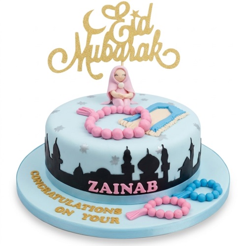 Light blue round Eid Mubarak cake with mosque silhouette, prayer beads, prayer mat, and praying figure.