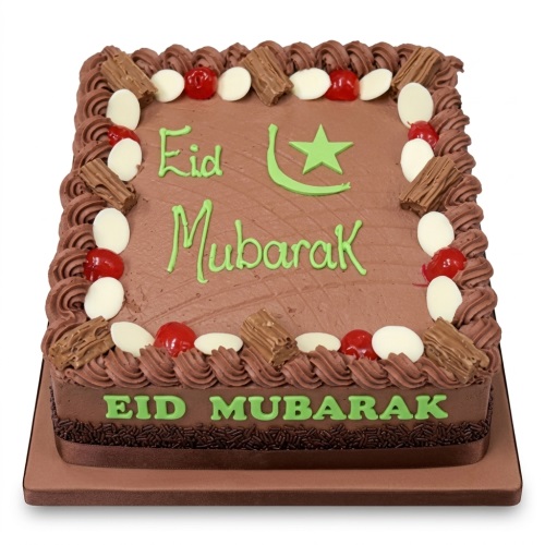 Square chocolate Eid Mubarak cake with green icing, star and crescent, chocolate flakes, cherries, and white chocolate buttons.