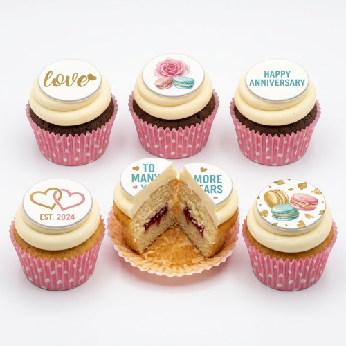 Anniversary cupcakes with rose, macarons, and custom love messages on white toppers.