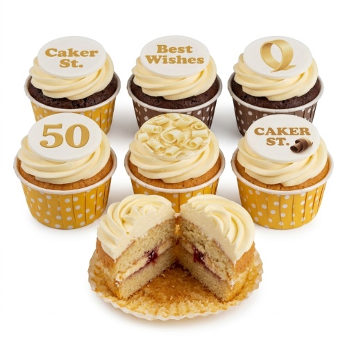 Selection of vanilla and chocolate cupcakes with white frosting, gold custom age topper, and chocolate curls.