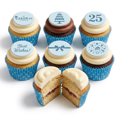 Assortment of vanilla and chocolate cupcakes with white frosting and light blue custom celebration toppers, including a cake, bow, confetti, and custom age.