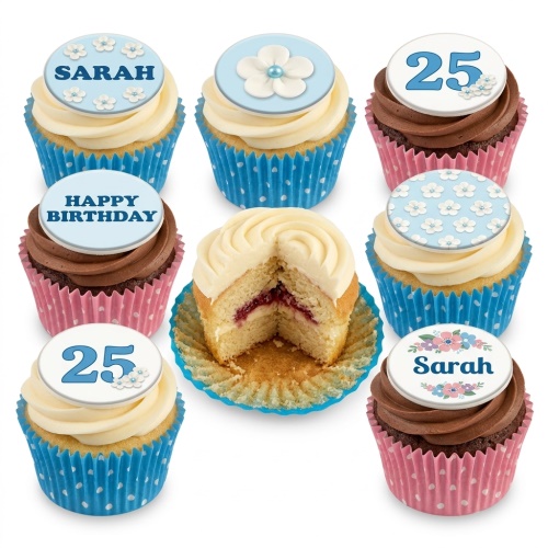 Assortment of floral birthday cupcakes with custom age and name toppers in blue and pink cases.