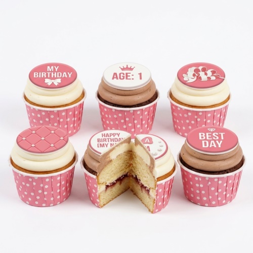 Set of pink and white birthday cupcakes with various toppers including bows, quilted patterns, and custom age example.