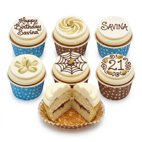 A selection of elegant birthday cupcakes with creamy frosting, featuring custom age and name decorations, pistachio accents, and a chocolate spiderweb.