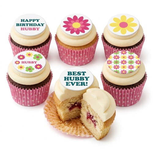 Floral cupcakes with white frosting, pink wrappers, and edible flower and message toppers.