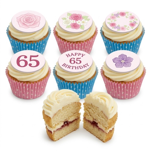 Floral birthday cupcakes with white frosting, pink and blue cases, and edible flower and custom age 65 toppers.