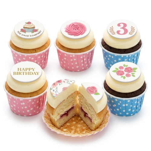 Assortment of floral and custom age birthday cupcakes in pink and blue polka dot cases with cream frosting.