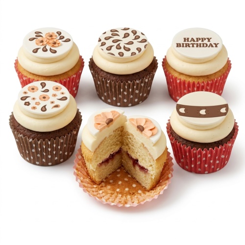 Assorted cupcakes with Happy Birthday, floral, paisley, and patterned toppers on cream frosting in red and brown cases.