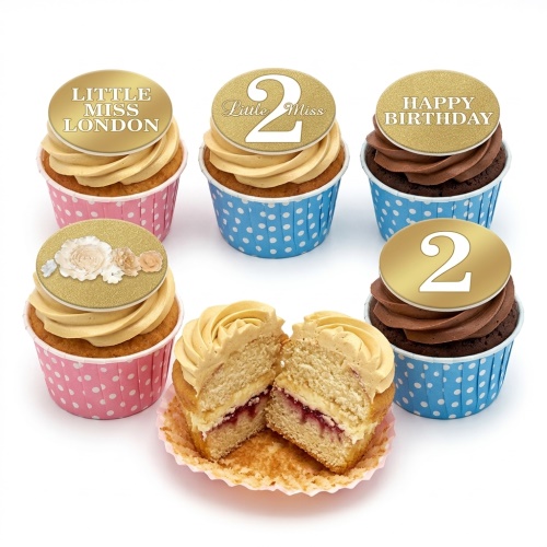 Six birthday cupcakes with gold glitter toppers, some with 'Little Miss' text, custom age '2', and floral designs, in pink and blue polka dot cases.