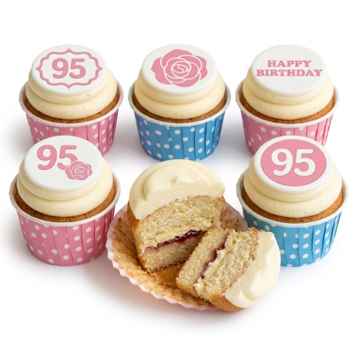 Vanilla cupcakes with cream frosting, pink and blue polka dot cases, and edible toppers featuring roses, 'Happy Birthday' text, and custom age numbers.