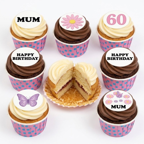 Cupcakes with floral, butterfly, custom age, and 'Happy Birthday' toppers in pink polka dot wrappers.