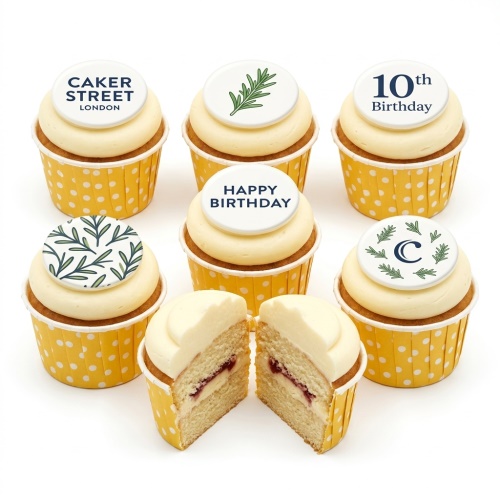 Floral birthday cupcakes with white frosting and custom leaf and message toppers in yellow polka dot cases.