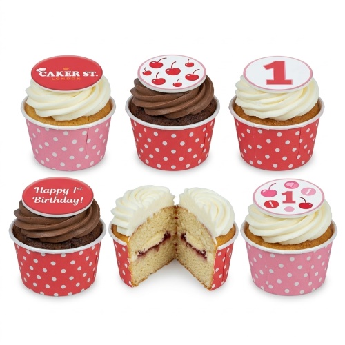 Set of 1st birthday cupcakes with cherry and number one toppers, in red and pink polka dot wrappers.