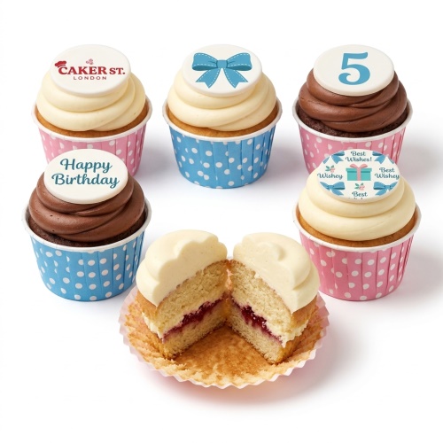 Assortment of kids birthday cupcakes with custom age topper, bows, and 'Happy Birthday' message in pink and blue polka dot wrappers.