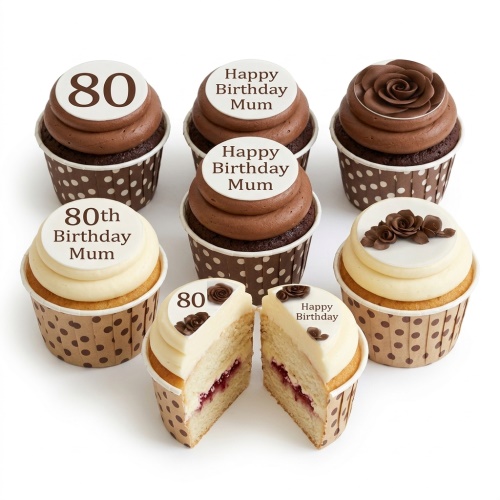 A selection of birthday cupcakes with chocolate and vanilla frosting, topped with edible white discs featuring chocolate roses, numbers, and 'Happy Birthday' messages, in polka dot cases.