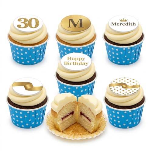 Six cupcakes with white icing, gold custom age, initial, name, and decorative toppers in blue polka dot wrappers.