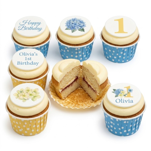 Cream cupcakes with blue and yellow floral toppers, "Happy Birthday" text, and a gold number one.