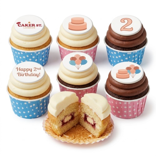 Vanilla and chocolate cupcakes with cream frosting, polka dot wrappers, and birthday celebration toppers including balloons, a cake, and an age topper.