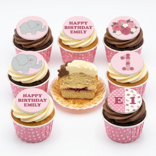 Pink cupcakes with elephant, floral, and custom age '1' toppers, in polka dot wrappers.