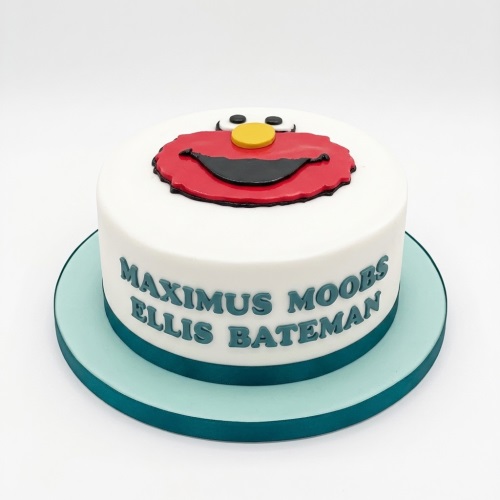 Round white cake with Elmo's face on top and a personalised name on the side.