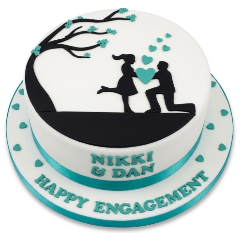 White engagement cake with black proposal silhouette, teal hearts, and a custom message on the board.
