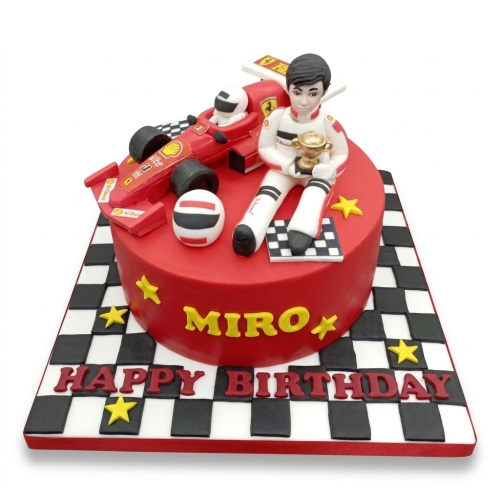 Red racing car birthday cake with driver figure, trophy, helmet, and checkered flag board.