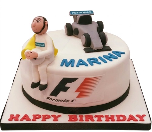 White round cake with Formula 1 car, driver figure, and F1 logo.