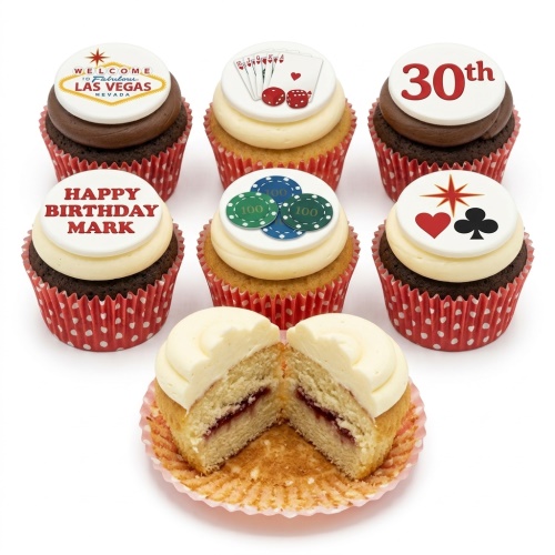 Six casino themed cupcakes with Las Vegas sign, playing cards, poker chips, and card symbols toppers. One cupcake is cut open revealing a jam filling.