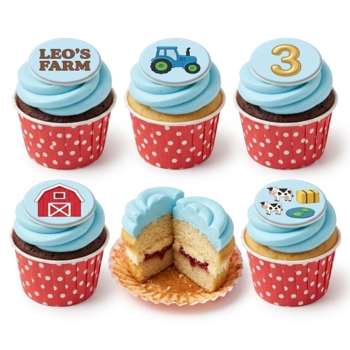 Farm theme cupcakes with blue frosting, tractor, barn, and cow toppers, in red polka dot wrappers.