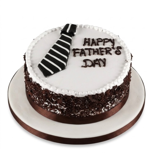 Round white cake with a black and white striped tie decoration and 'Happy Father's Day' text, surrounded by chocolate shavings.