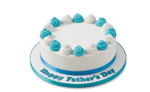 Round white cake with blue and white piped swirls, blue ribbon, and "Happy Father's Day" message.