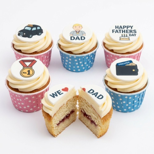 A set of six Fathers Day themed cupcakes with white frosting and various edible toppers including a taxi, "DAD" character, "Happy Fathers Day" message, "No. 1" medal, and a wallet. One cupcake is cut in half revealing "WE ❤️ DAD".