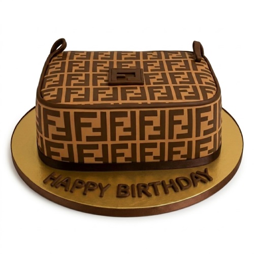 Fendi-inspired handbag birthday cake with brown and tan logo pattern on a gold board with 'Happy Birthday' message.
