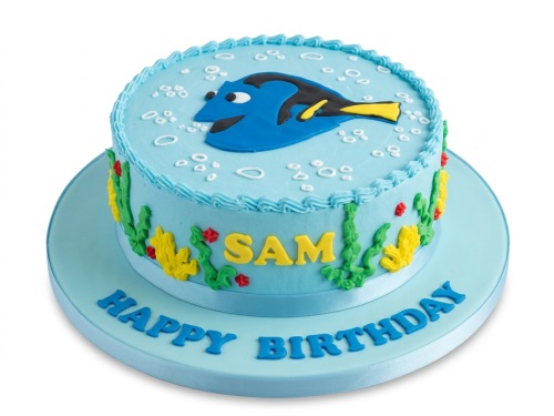 Round blue Dory birthday cake with green seaweed, yellow coral, and white bubbles.