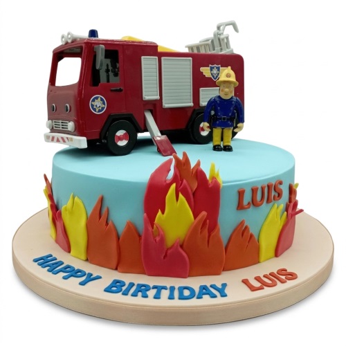 Round blue fondant cake with a red toy fire engine and fireman figure on top, surrounded by edible red, orange, and yellow flames.
