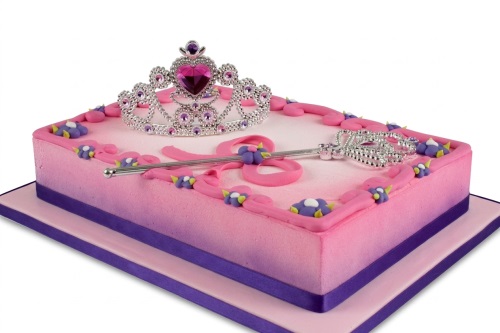 Pink rectangular princess birthday cake with a silver tiara, wand, and purple ribbon.