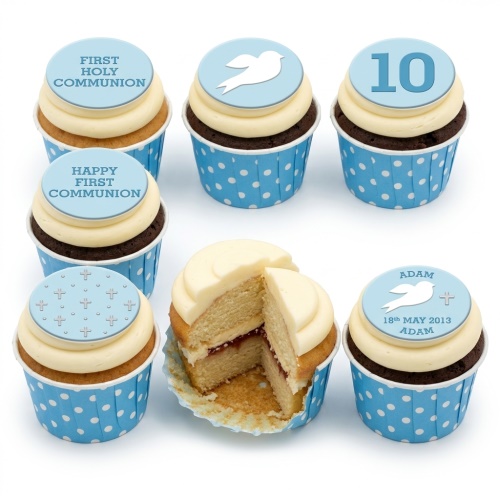 First Holy Communion cupcakes with blue and white dove and cross toppers, some with custom text and numbers.