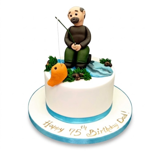 White round cake with a fondant fisherman figure, fishing rod, orange fish, and green foliage.