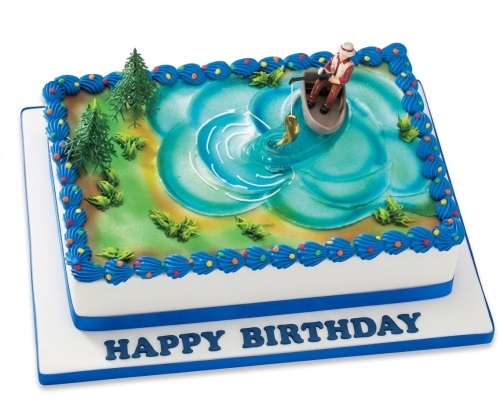 Rectangular birthday cake with a fishing scene, featuring a fisherman in a boat on a blue lake with green trees.